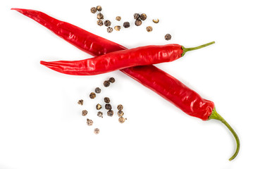 rote Peperoni und Pfefferkörner auf weiß