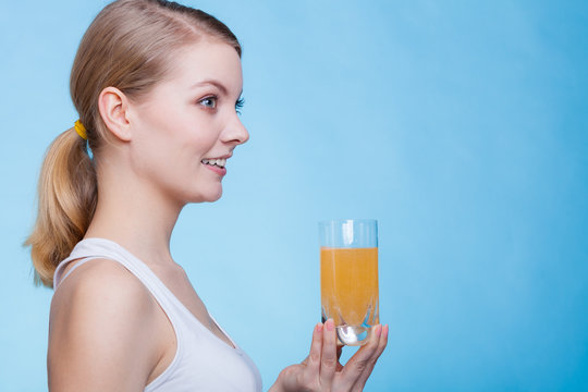 Woman holding glass of orange flavored drink
