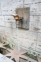 Water running from a tap of the natural source of Passy in the middle of Paris