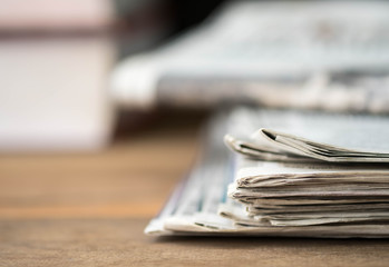 Pile of newspaper on the wood table.