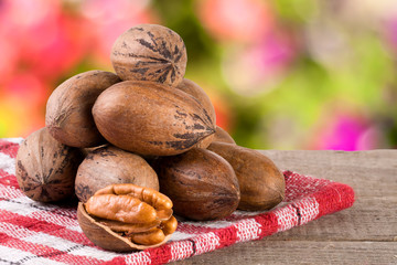 a bunch of pecan nuts on a wooden background