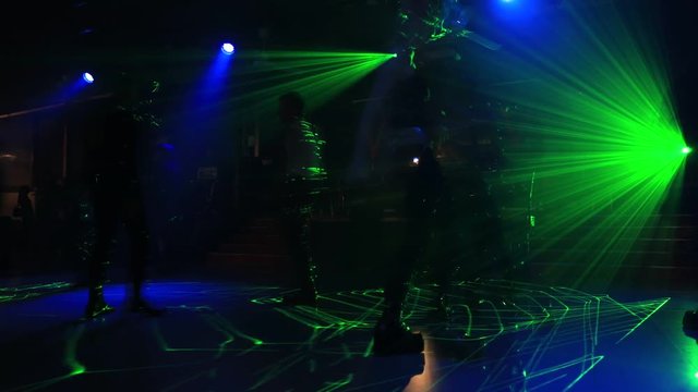 Timelapse of dancing people on dance floor background of a disco pub with violet, blue and pink strobe lights. Entertainment, leisure and nightlife concept. Adult lifestyle.