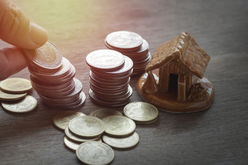 pile of coins and home, concept in house finance, account, buy and sell home on wood table