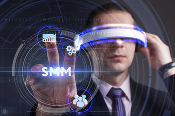 Business, Technology, Internet and network concept. Young businessman working in virtual reality glasses sees the inscription: SMM