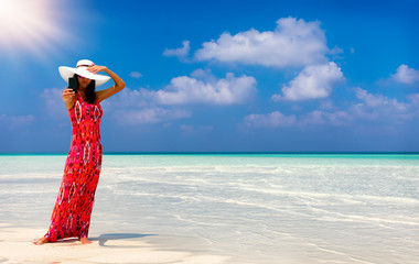 Attraktive Frau im roten Kleid macht ein Selfie Foto von sich am Strand der Malediven