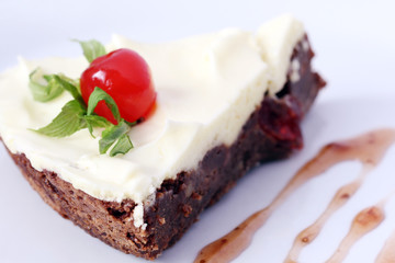 isolated served slice of delicious chocolate brownie cake with cherry
