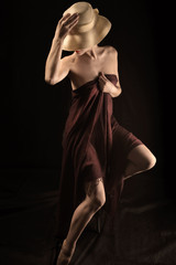 Fototapeta premium Beautiful naked woman covering body with brown cloth , a photo full length in the brown colors.