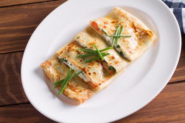 Healthy Breakfast crepes with bacon, cheese, greens, tomatoes on a wooden table. Selective focus