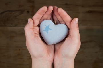 Obraz premium Heart from cloth on wood desk