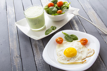 Food fried egg spinach salad wood background
