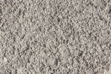 White arid cracked lumpy dry textured desert soil from above