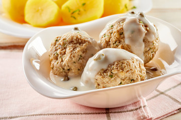 Herbed golden potatoes served alongside meatballs
