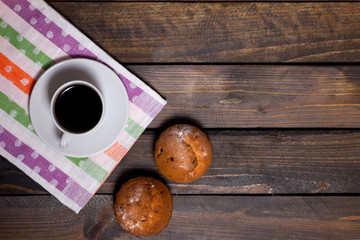 Coffee in white cup with two cupcakes