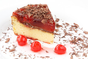 isolated on white served slice of delicious cherry cheese cake with cherry topping and decorated with chocolate