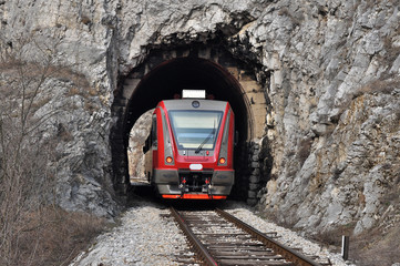 Obraz premium The train on the railway line comes from a small tunnel, New train on old railway.