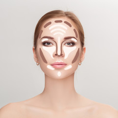 Contouring. Make up woman face on grey background.  Professional