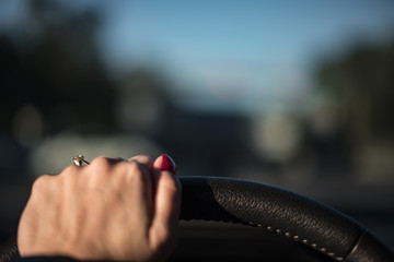 Female driving car holding steering wheels