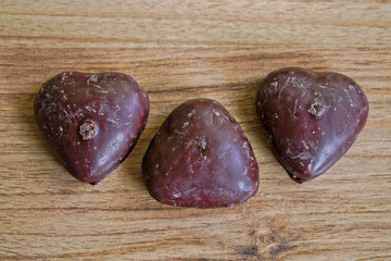 Chocolate covered gingerbread hearts on a wooden table