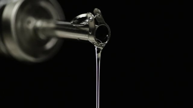 MACRO FOOD: Sunflower oil is pouring on a black background