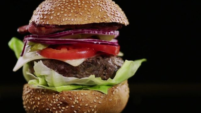 SLOW MOTION FOOD: a piece of bread falls on the finished burger and chips fly