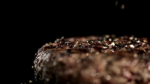 MACRO FOOD: small pieces of pepper falling juicy steak in slow motion