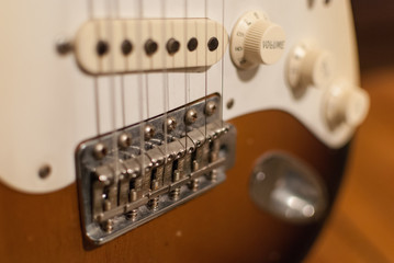Fototapeta na wymiar Vintage Fender Stratocaster electric guitar sunburst body close up with worn volume and tone knobs