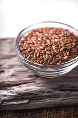 Linen seeds in a little bowl on wooden table