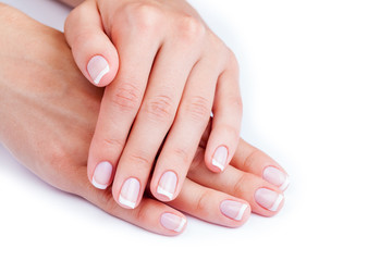 Fototapeta premium Woman hands with french manicure isolated on a white background