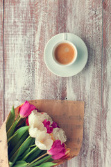 tulips and coffees isolated on a wooden table