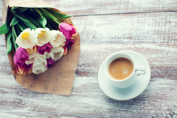 tulips and coffees isolated on a wooden table