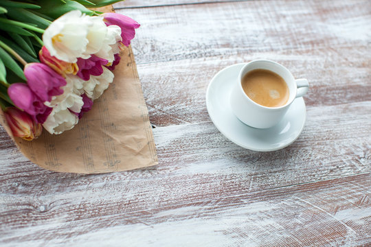 tulips and coffees isolated on a wooden table
