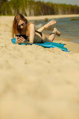 Woman in bikini sunbathing and relaxing on beach