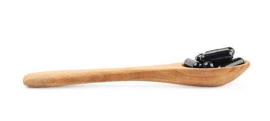 Spoon full of capsule pills isolated