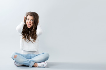 Beautiful girl sitting on the floor cross-legged.