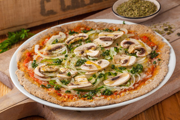 Whole wheat pizza with tomato, cheese, onions, mushrooms and oregano.