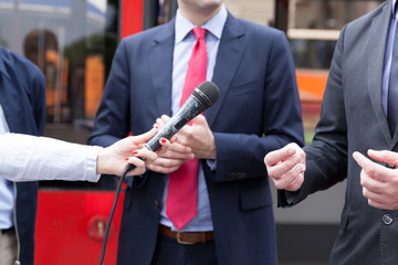 Journalist holding microphone, conducting media interview. Press conference.