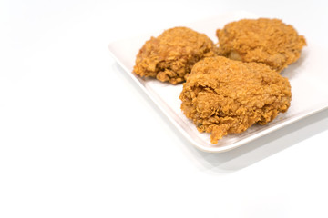 fried chicken thigh on a white plate - isolate white background with copy space.