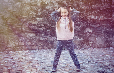 Cute blond girl over rock background.