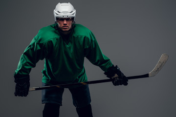 Portrait of hockey player isolated on grey background.
