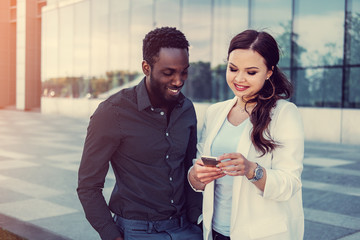 Black male and brunette Caucasian woman in a downtown.