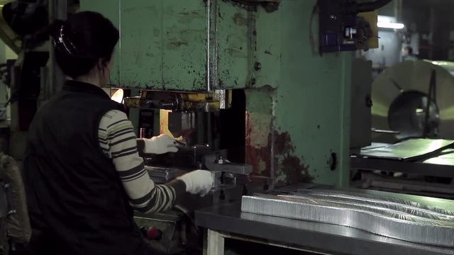 Hard work of the women worker at the forming machine
