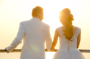 Fototapeta na wymiar Sunset Wedding. Bride and Groom Holding Hands at Sunset .