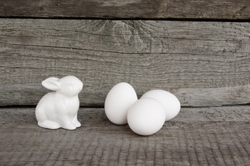 White rabbit and eggs on vintage wooden background.  Easter's Background. Retro style postcard.