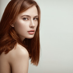 Beauty portrait of young beautiful sexy red-haired model with long straight hair.