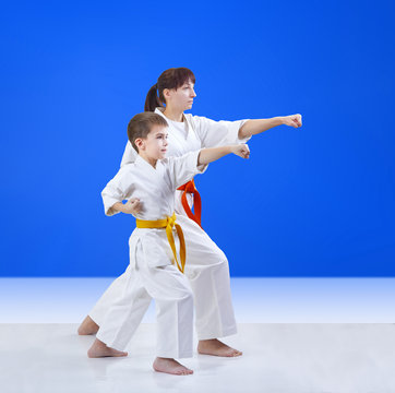 On a blue background mother and son are hitting a punch arm