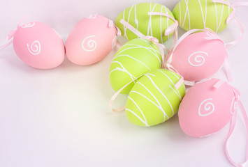 Easter pink and green painted eggs on white background and copy space.