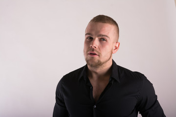 Close up Smiling Young Businessman Wearing Eyeglasses, Looking at the Camera Against Gray Wall Background with Copy Space