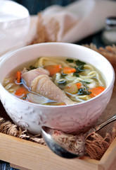Soup with homemade noodles and organic chicken with carrots, root and leaves of parsley, onion and celery sticks.
