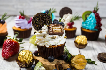 Chocolate cupcakes. Cupcakes with berries,fruit,strawberries. Top view.colorful cupcake,tasty cake,colorful cream,cupcakes with summer berries on wooden background,close up,dessert concept