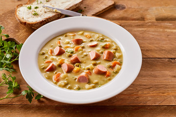 Bowl of Creamy Pea Soup with Chopped Sausage